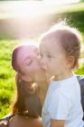 Mère embrasser tout-petit dans le parc — Photo de stock