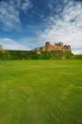 Castle with lawn under blue cloudy sky — Stock Photo
