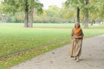 Старшая женщина, гуляющая в парке — стоковое фото