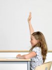 Ragazza alzando la mano in classe — Foto stock