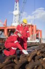 Trabajadores en plataformas petrolíferas que examinan cadenas - foto de stock