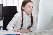 Дівчина використовує комп'ютер в офісі — стокове фото