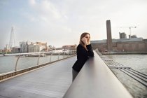 Donna al cellulare su Millennium Bridge, Londra, Inghilterra, Regno Unito — Foto stock