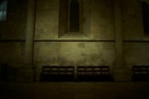 Скамейки в темном интерьере церкви — стоковое фото