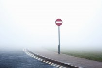 Road with no entry sign in fog — Stock Photo