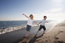 Мальчик и девочка бегают по пляжу — стоковое фото