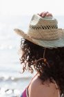 Visão traseira da mulher usando chapéu de sol na praia — Fotografia de Stock