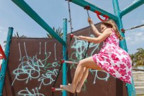 Дівчина на дитячому майданчику драбини на відкритому повітрі — стокове фото
