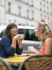 Женщины пьют кофе в кафе на тротуаре — стоковое фото