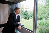 Бизнесмен смотрит в окно офиса — стоковое фото