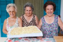 Older women with basket of pasta, focus on foreground — Stock Photo