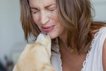 Улыбающаяся женщина играет с собакой — стоковое фото