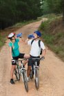 Couple drinking water on mountain bikes — Stock Photo