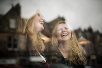 Женщины смеются над окном, избирательный фокус — стоковое фото