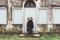 Портрет пары, стоящей спиной к спине в дверях старого дома — стоковое фото