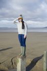 Молодая женщина, стоящая на паху, Брин Сэндс, Сомерсет, Англия — стоковое фото