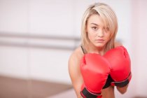 Retrato de jovem mulher em luvas de boxe — Fotografia de Stock