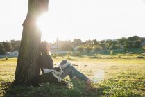 Жінка розслабляється з собакою в парку — стокове фото