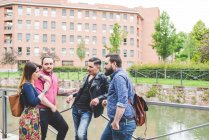 Group of friends chatting by river together — Stock Photo