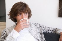 Підлітковий хлопчик п'є чашку кави — стокове фото