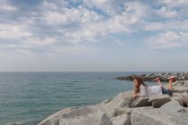 Дівчина відпочиває на кам'янистому пляжі — стокове фото