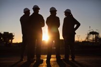 Silhouette dei lavoratori della raffineria di petrolio — Foto stock