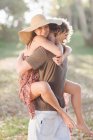 Sorridente coppia che si abbraccia in campo — Foto stock