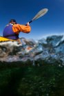 Жінка каякинг дивиться з під водою — стокове фото