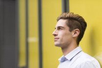 Portrait of young businessman leaning outside office, London, UK — Stock Photo
