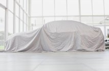 Car covered in cloth — Stock Photo