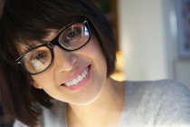 Donna con gli occhiali, sorridente alla macchina fotografica — Foto stock
