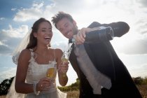 Pareja recién casada tomando champán - foto de stock