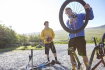 Велосипедист прикрепляет велосипедное колесо к велосипеду — стоковое фото