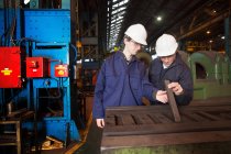Рабочие, изучающие металл в стальной кузнице — стоковое фото