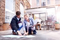 Businesswoman and man looking at paperwork on office patio floor — Stock Photo