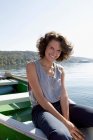Donna penzoloni piedi dalla barca nel lago — Foto stock