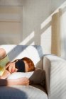 Donna che dorme con maschera sul divano — Foto stock