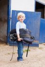 Хлопчик, що носить конячий сідло, зосередьтеся на передньому плані — стокове фото
