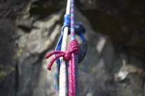 Primer plano de la cuerda de escalada contra piedras de montaña - foto de stock