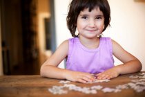 Adorable little girl puzzling — Stock Photo