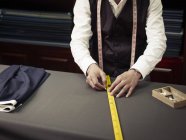 Tailor chalking measurements in traditional tailors shop — Stock Photo