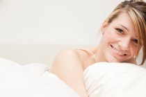 Portrait of young woman in bed — Stock Photo