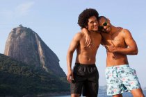 Deux amis sur la plage avec les bras l'un autour de l'autre, Rio de Janeiro, Brésil — Photo de stock