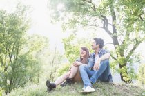Jovem casal sentado na grama, Piemonte, Itália — Fotografia de Stock
