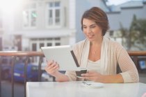 Жінка використовує планшетний комп'ютер у кафе — стокове фото