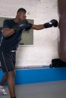 Боксер використовує мішок для удару в тренажерному залі — стокове фото