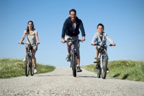 Family cycling down country road — Stock Photo