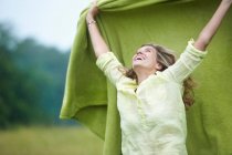 Жінка тримає ковдру на відкритому повітрі, вибірковий фокус — стокове фото