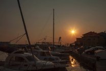 Sole che tramonta sul porto urbano — Foto stock
