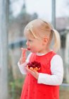 Toddler girl eating fruit cake — Stock Photo